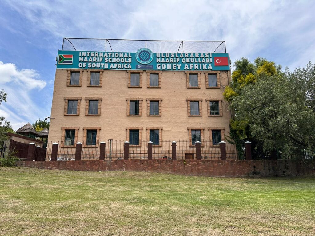 International Maari Schools of South Africa signboard with Turkish flag and school name on a brick building, representing international school ratings from South Africa and Turkey.