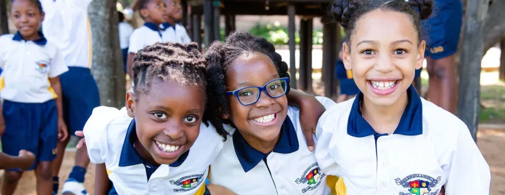 Happy school children smiling outdoors in school uniform, celebrating education and academic success for school ratings and reviews.