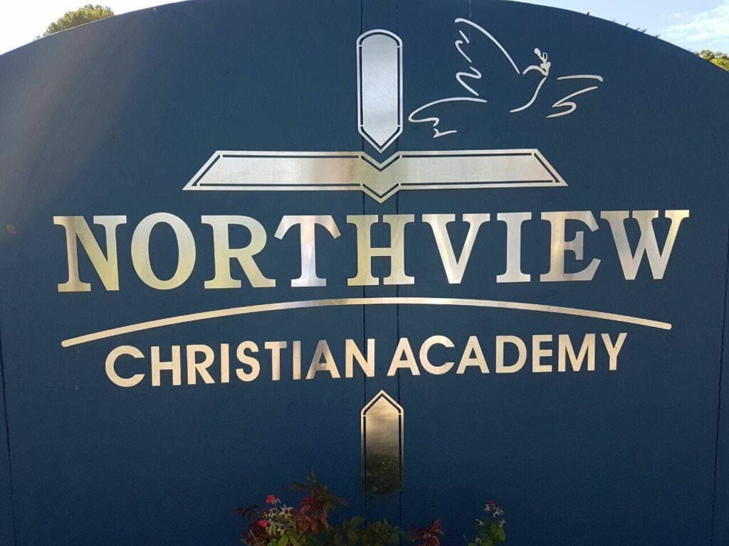 Bright blue school sign with "Northview Christian Academy" logo featuring a dove and open book, highlighting quality school ratings, Christian education, and academic excellence in South Africa.