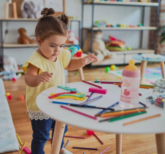 Little kindergarten girl at crafts table